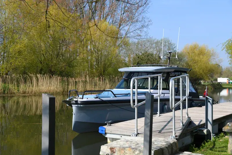 medium sized fishing boat tied to a small wooden pier